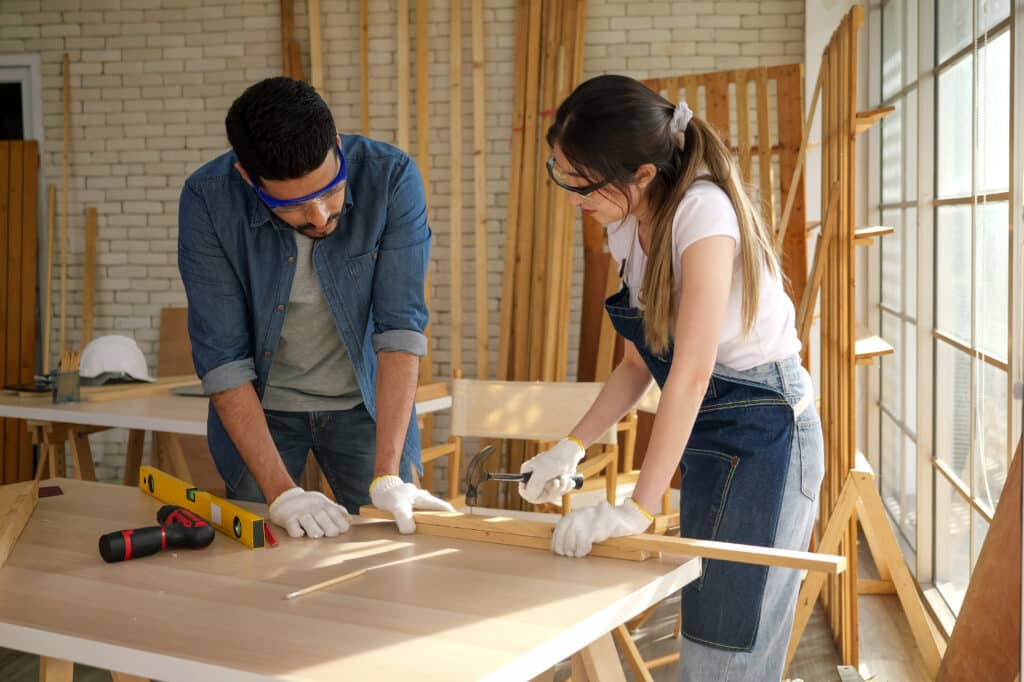 Sweet carpenter couple in workshop, Professional carpenter with handicraft working in carpentry shop