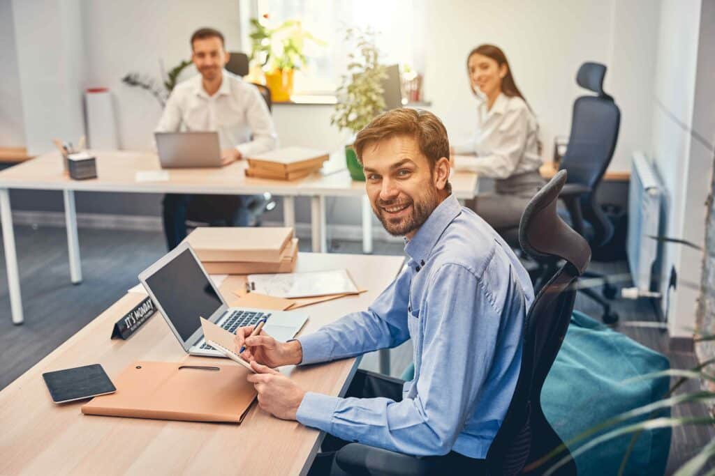 smiling-man-is-holding-notebook-at-workplace-2023-11-27-05-22-36-utc