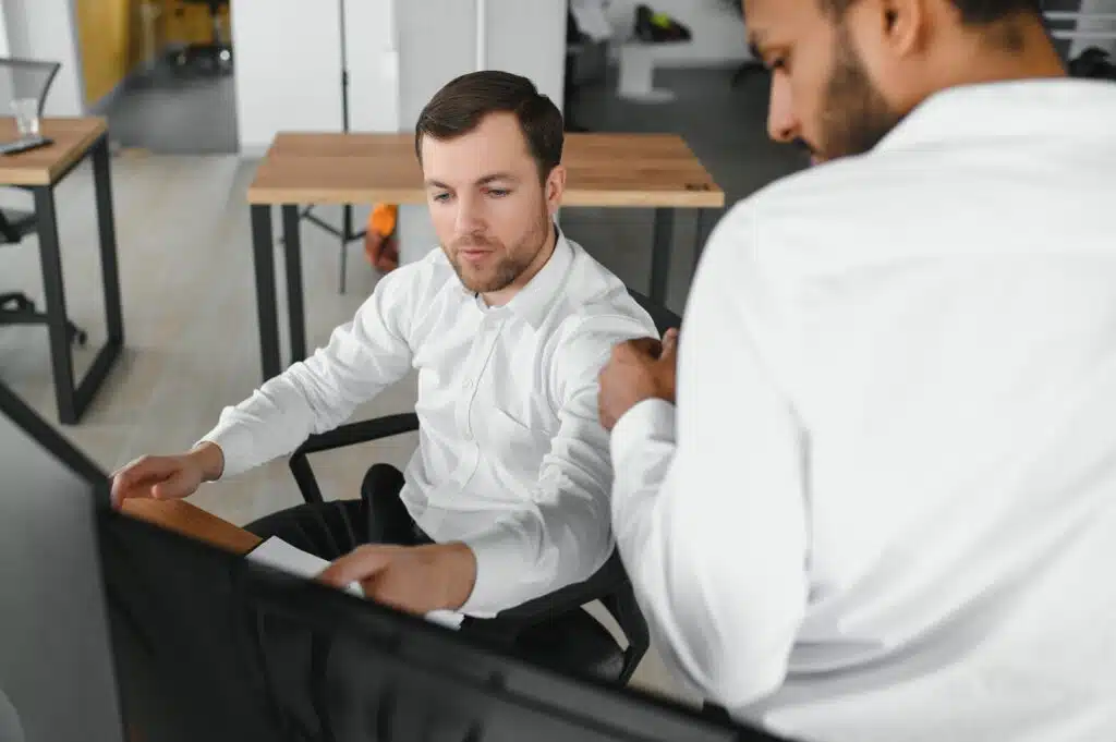 Two diverse crypto traders brokers stock exchange market investors discussing trading charts research reports growth using pc computer looking at screen analyzing invest strategy, financial risks