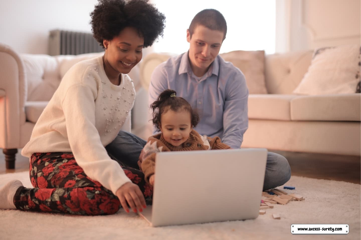 A picture family utilizing a laptop while seated on the floor.