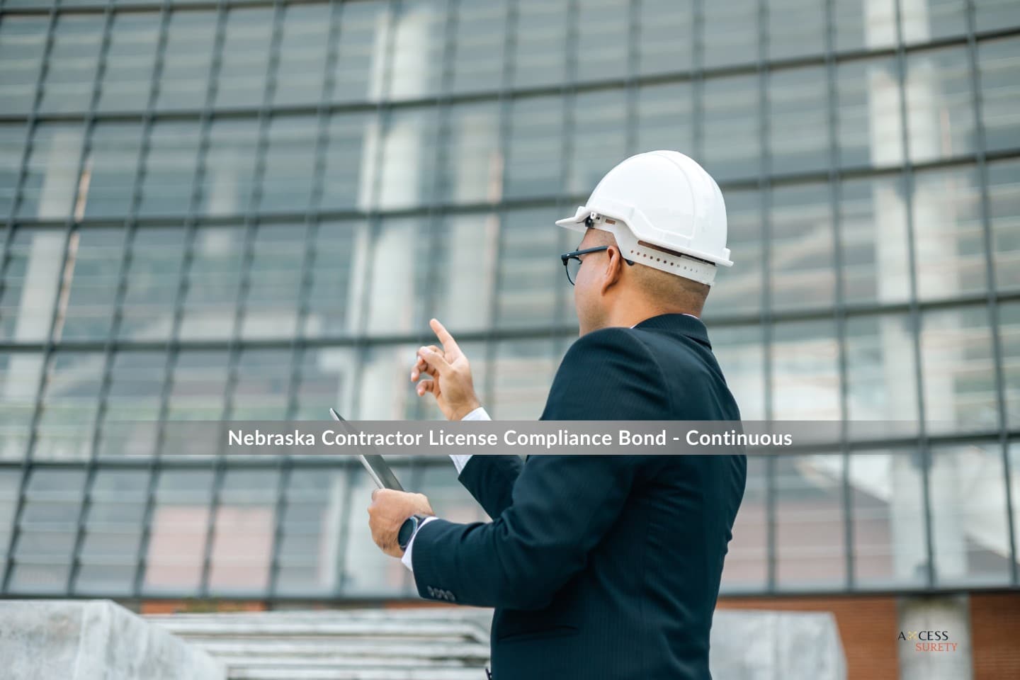 Nebraska Contractor License Compliance Bond - Continuous - Wearing a white hard hat and clutching a digital tablet, the contractor inspects the completed condominium apartment.