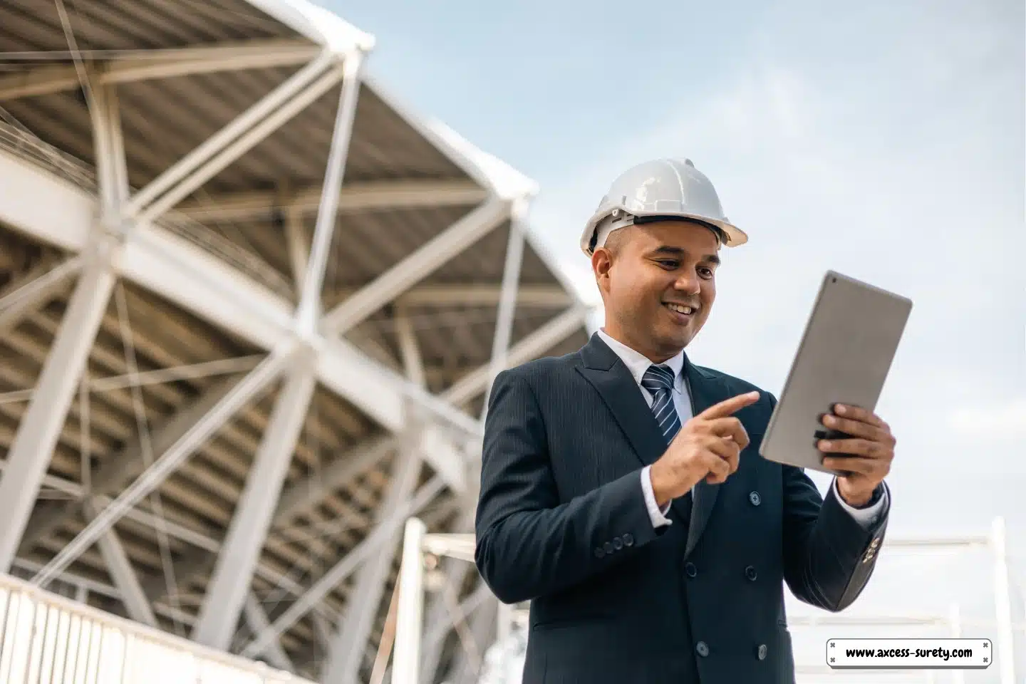 An entrepreneur and real estate owner is using a digital tablet at the newly erected skyscraper.