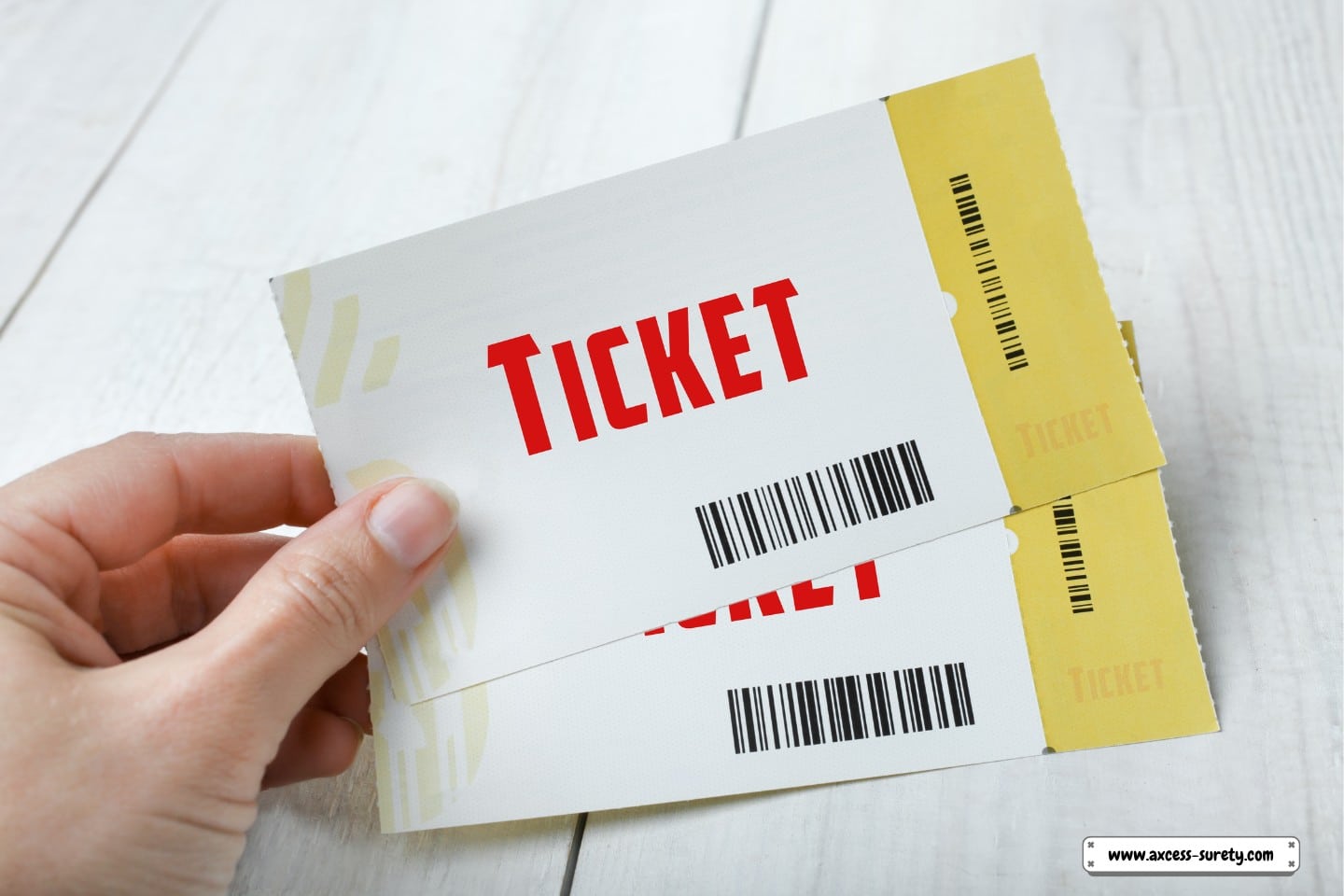 A wooden background with two tickets in hand.