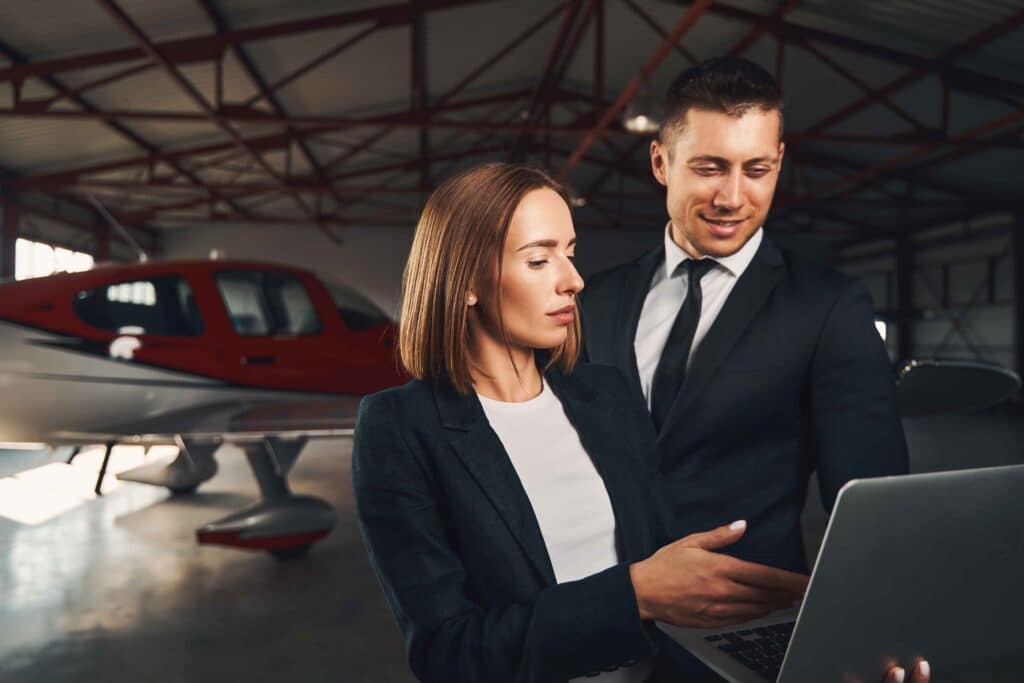 business-colleagues-using-laptop-in-aircraft-hanga-2024-10-18-13-17-14-utc_11zon