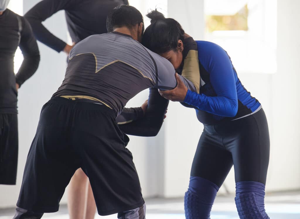 Cropped shot of a jiu jitsu sensei sparring with one of his students during a class.