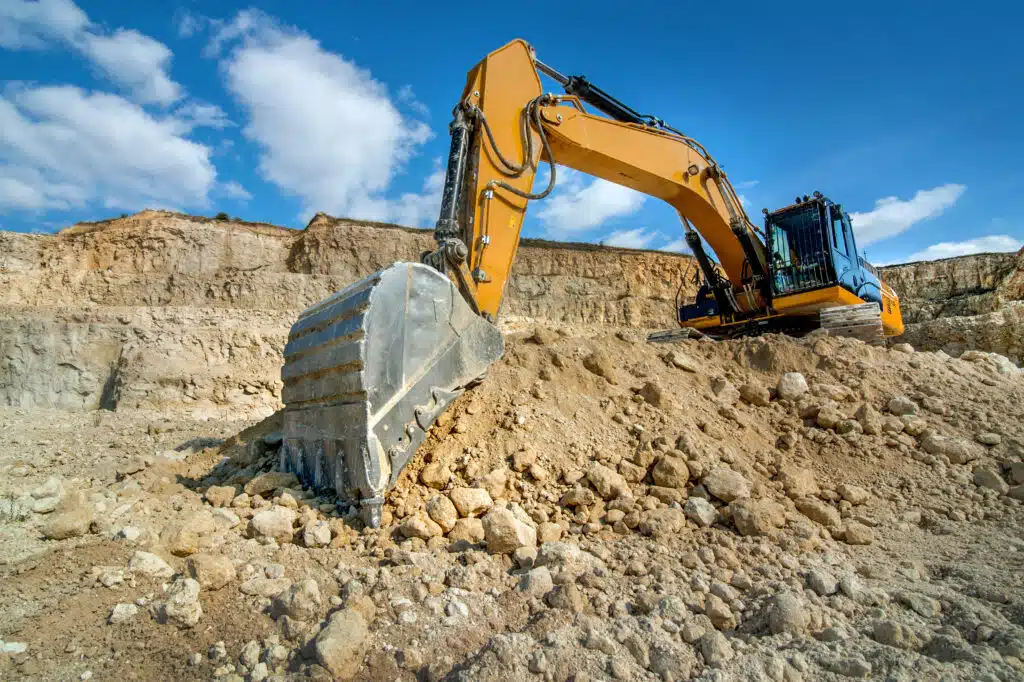 Excavator unload gravel at sandstone quarry. Construction industry.