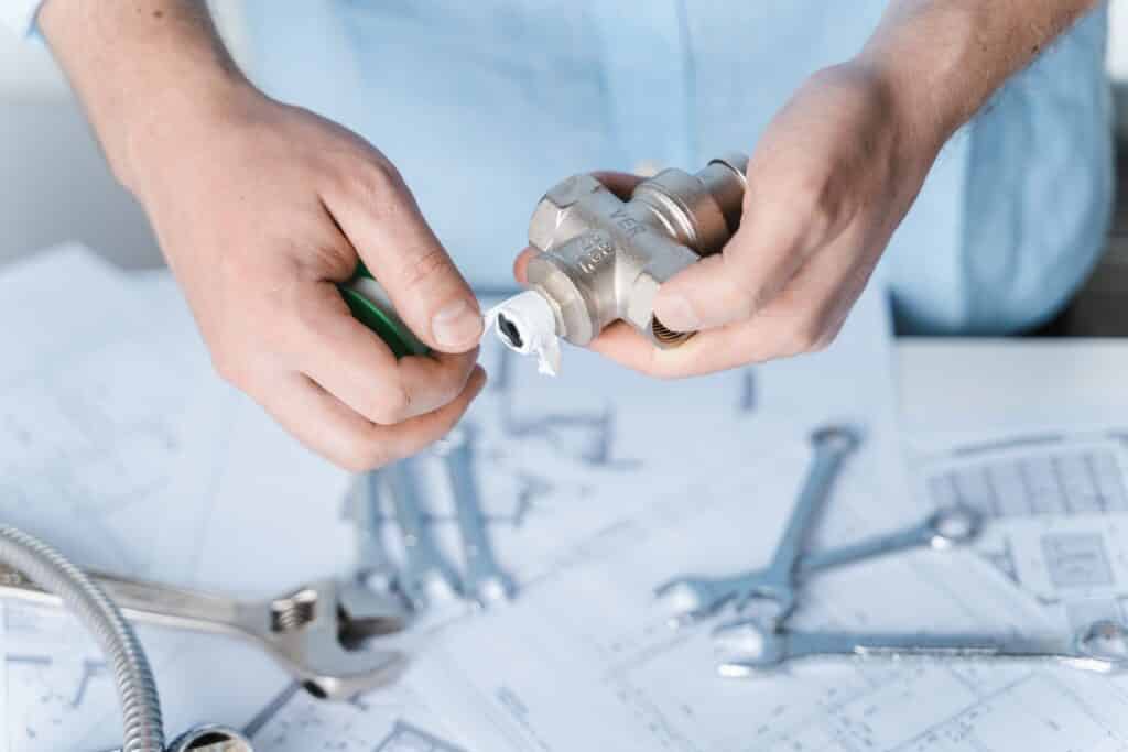 Plumbing project in house.Drawing,diagrams,plan of water supply of apartment,building.Man repairer making repairs at home.Devices,accessories, hose,tap,adjustable wrench,pressure reducer,tape measure.