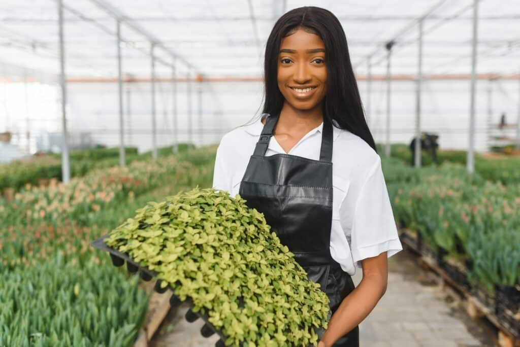pretty young african gardener portrait in greenhouse