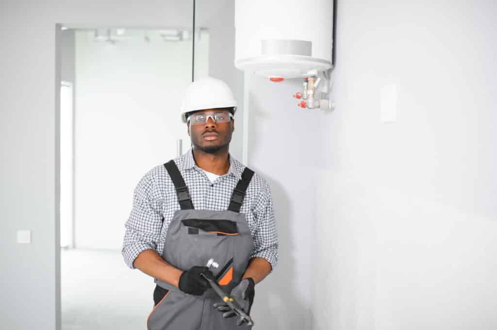 African american worker set up gas heating boiler at home.