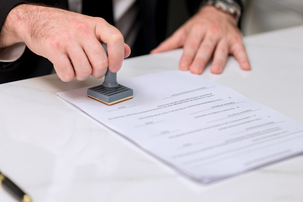 business-man-stamping-with-approved-stamp-on-docum-2024-07-24-18-44-41-utc