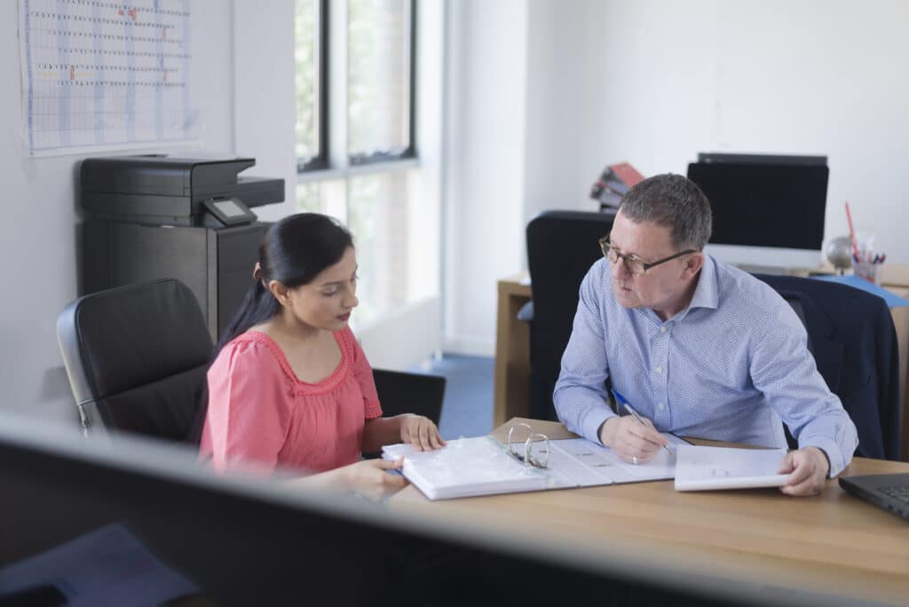 Colleagues in discussion at office desk