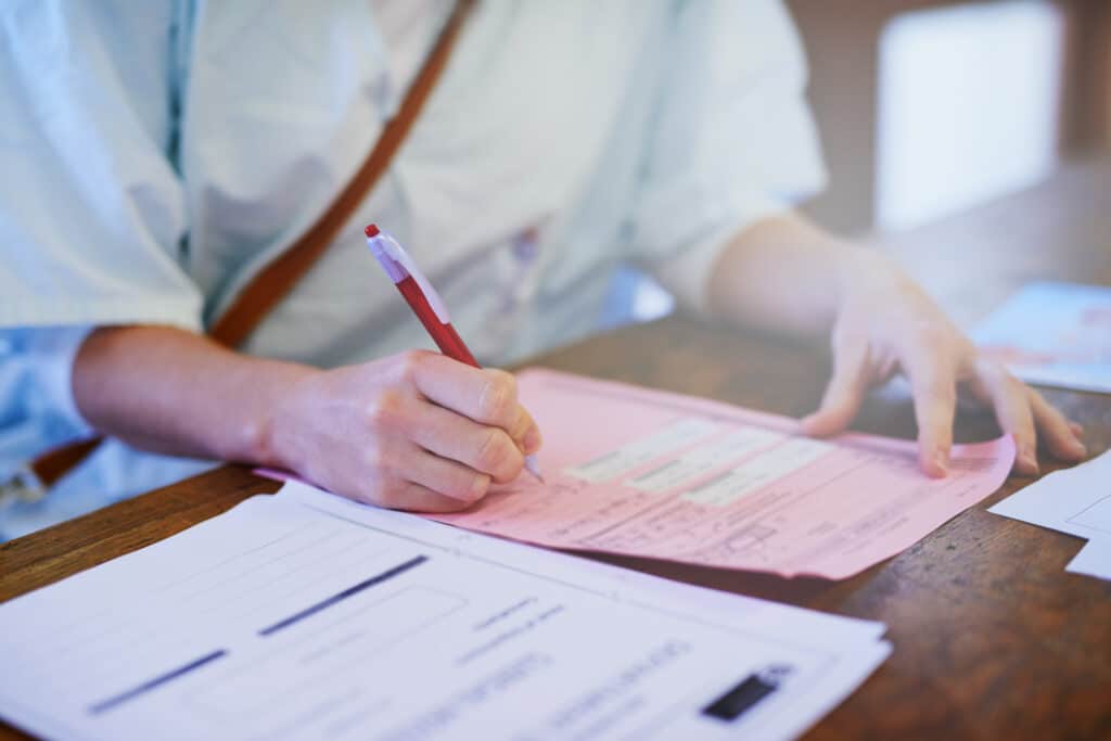 Important patient paperwork. Cropped shot of a doctor filling out paperwork in a hospital