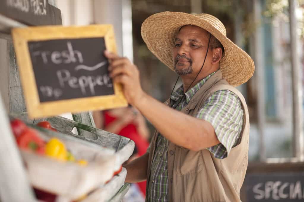 Market trader placing signage on rack