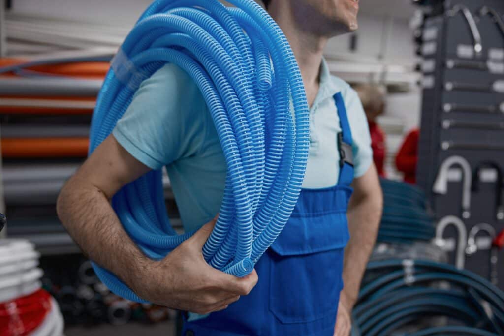 plumber-holding-roll-of-corrugated-plastic-water-p-2024-09-23-23-11-03-utc_11zon