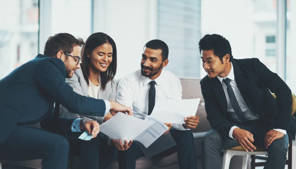 Shot of a group of businesspeople discussing paperwork while sitting together.