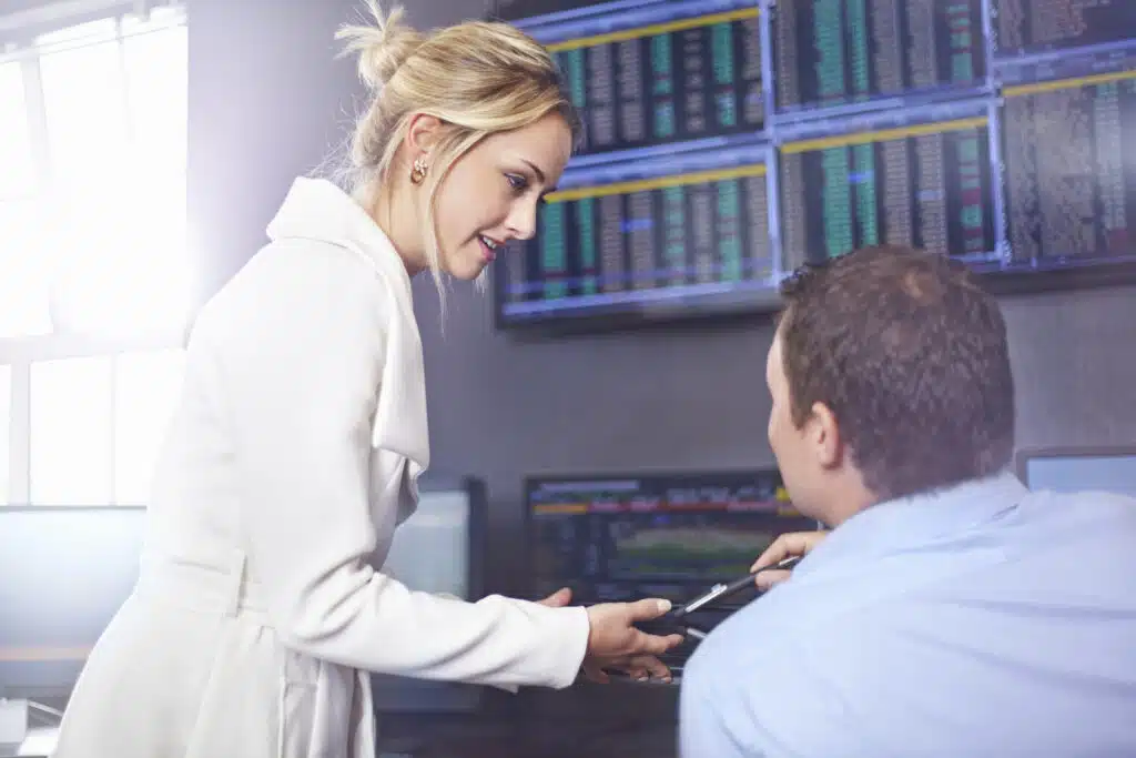 Side view of young business woman in office having discussion with colleague