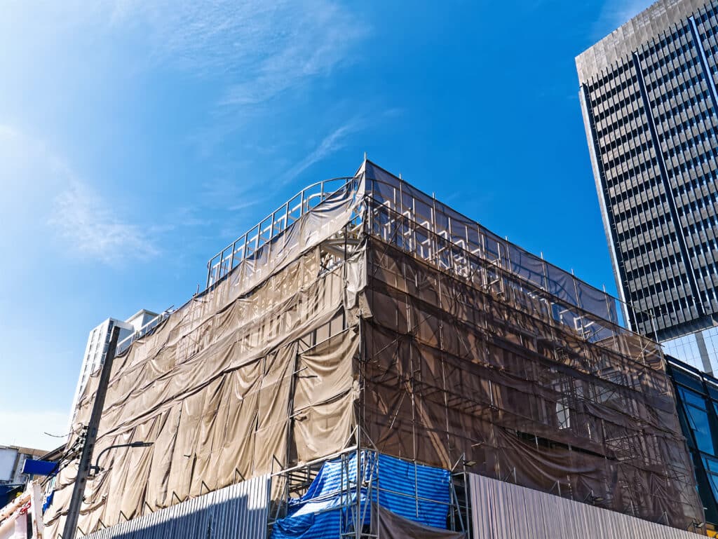 Low Angle View of Under Construction Building with Scaffolding Against Blue Sky