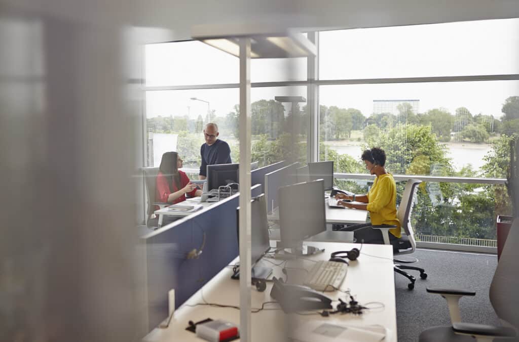 Woman with headset working in open-plan office